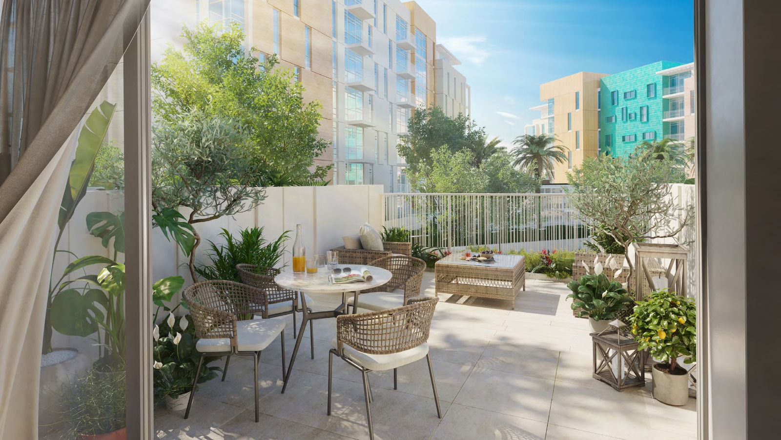 Private terrace with outdoor seating and planting overlooking apartment buildings at Uptown Zahia