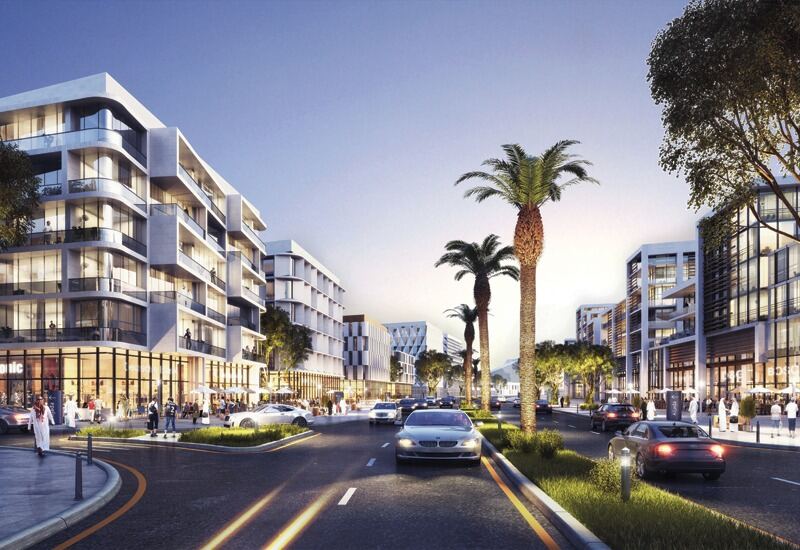 Palm lined boulevard with shops and supermarkets at street level in Aljada