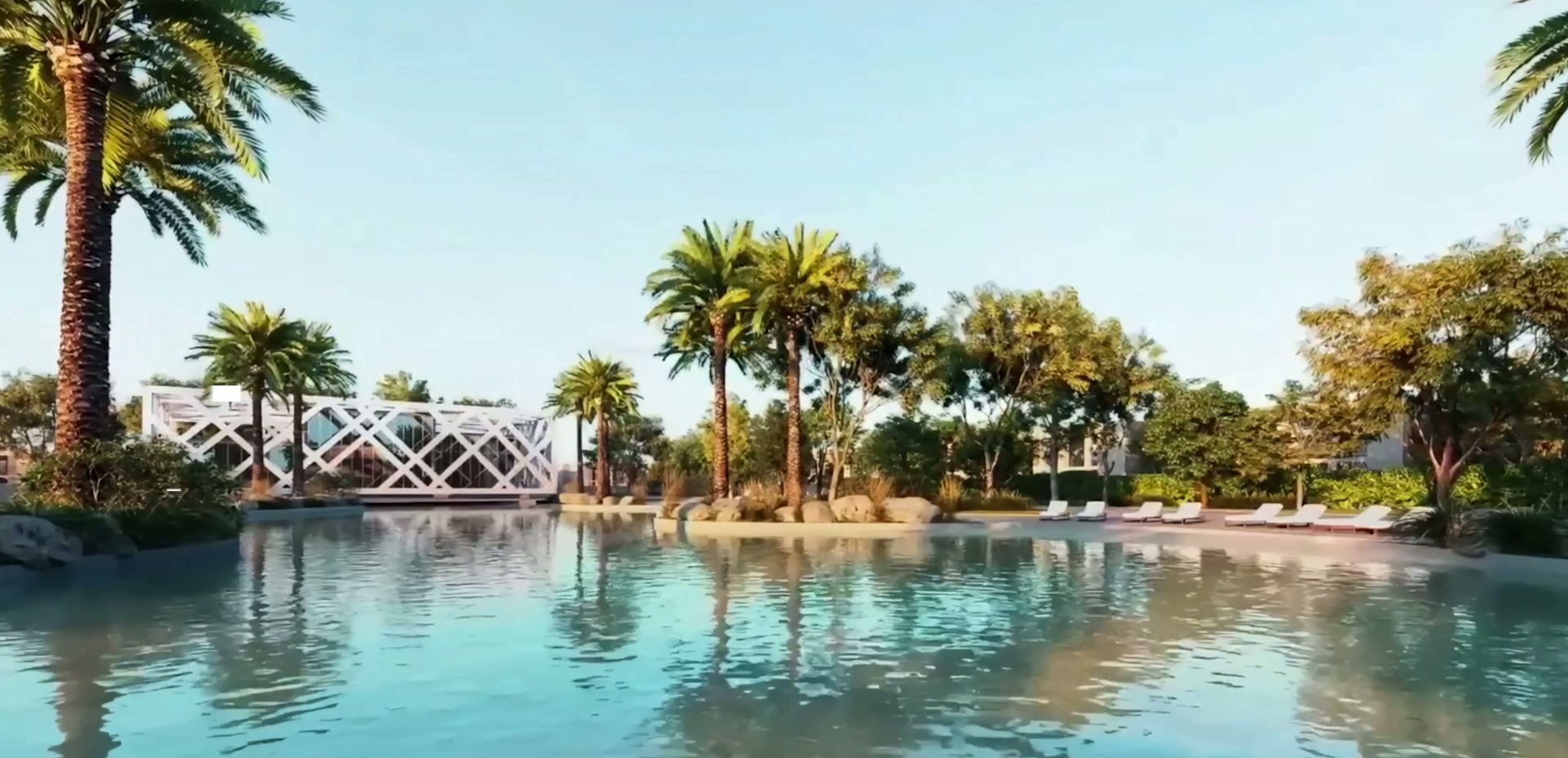 Crystal clear swimmable lagoon lined with palm trees and sandy shore at Hayyan, Sharjah