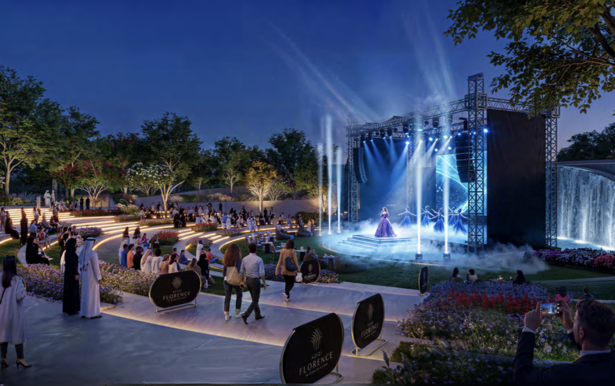 Evening performance on the open-air theatre stage with terraced lawn seating