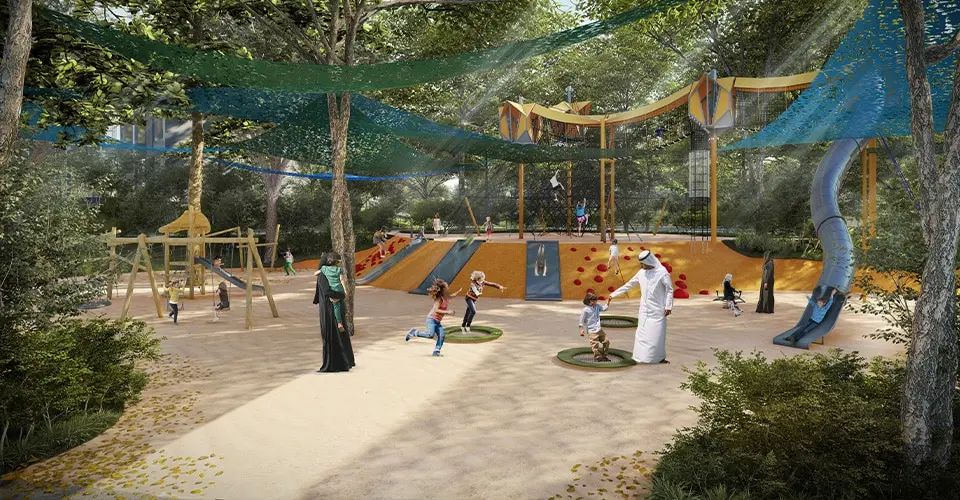 Children's playground with timber climbing frames under trees at Masaar