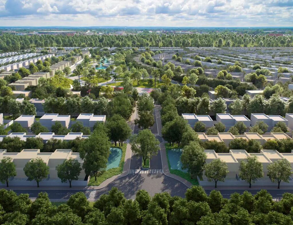 Aerial view of Hayyan showing tree lined streets and dense greenery across the community