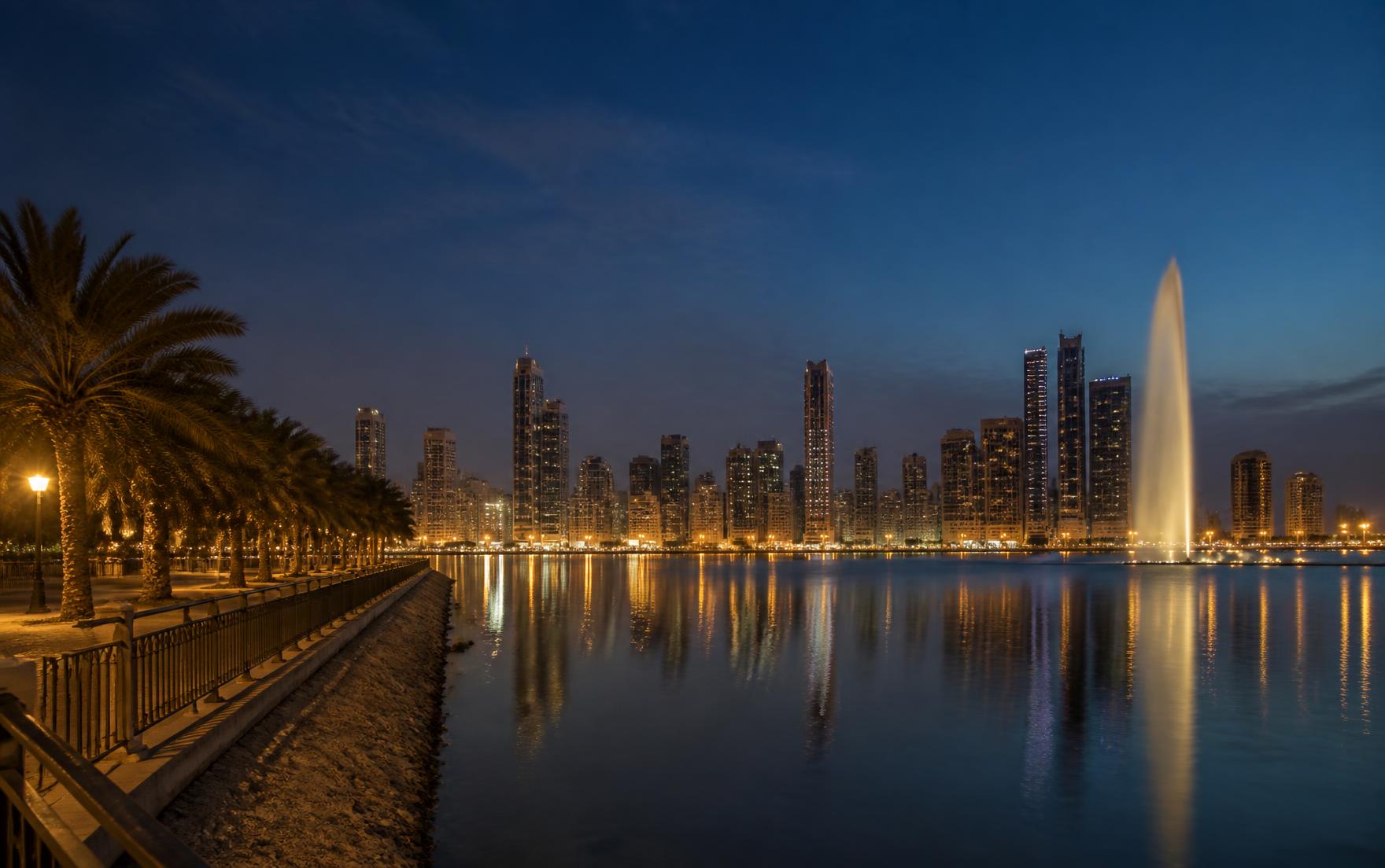 Sharjah skyline at dusk seen across Khalid Lagoon from the Al Majaz waterfront